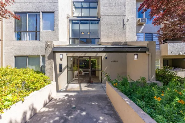 a view of a hallway with wooden floor and a bathroom
