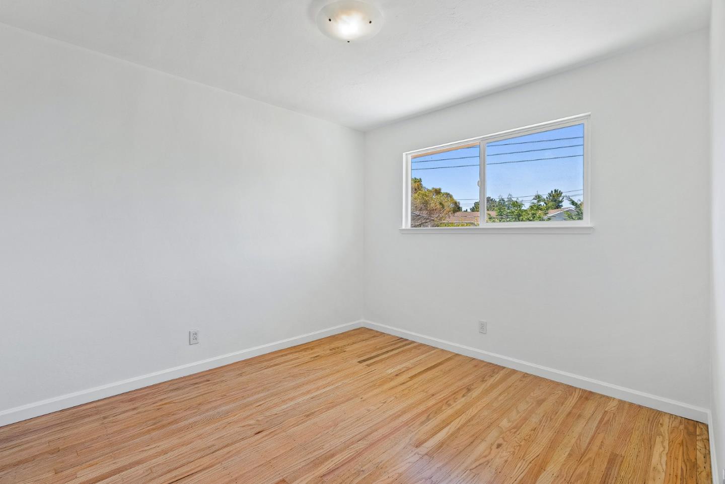 829 Monterey Avenue Capitola, CA 95010 - Photo 24 of 59 a view of an empty room with wooden floor and a window