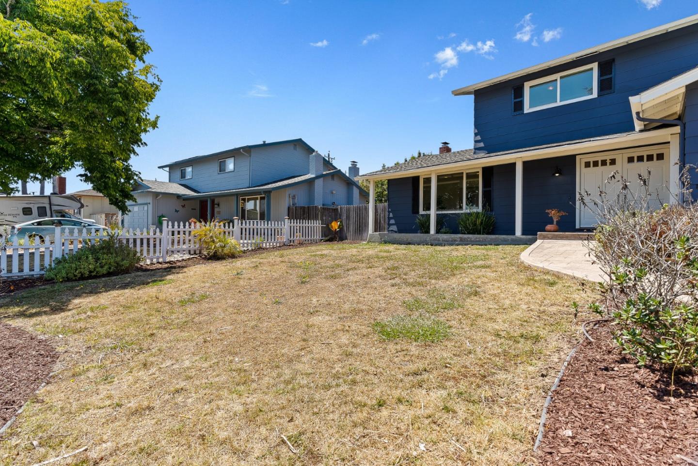 829 Monterey Avenue Capitola, CA 95010 - Photo 7 of 59 a front view of a house with a yard and table and chairs under an umbrella