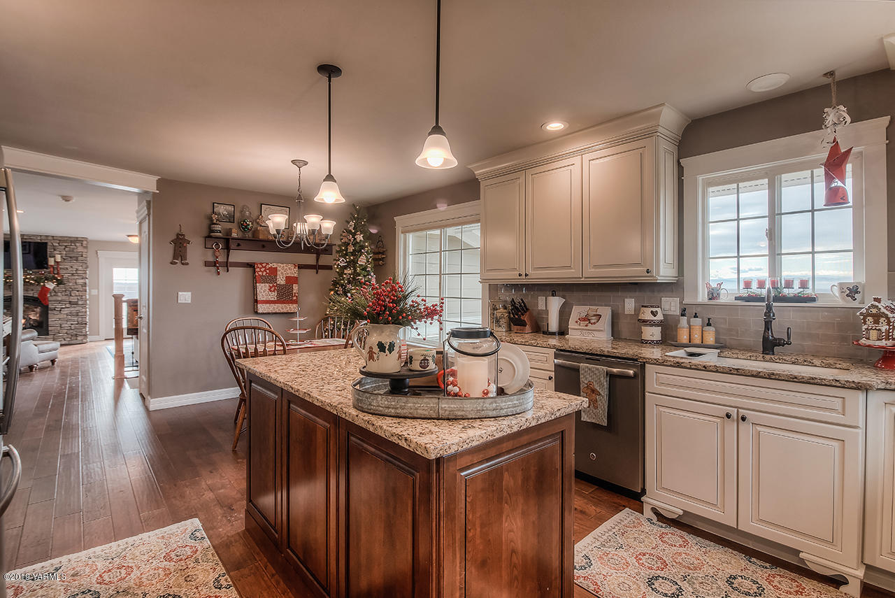 852 Clark Road Zillah, WA 98953 - Photo 14 of 55 a kitchen with a stove a sink dishwasher a kitchen island with wooden cabinets and floor