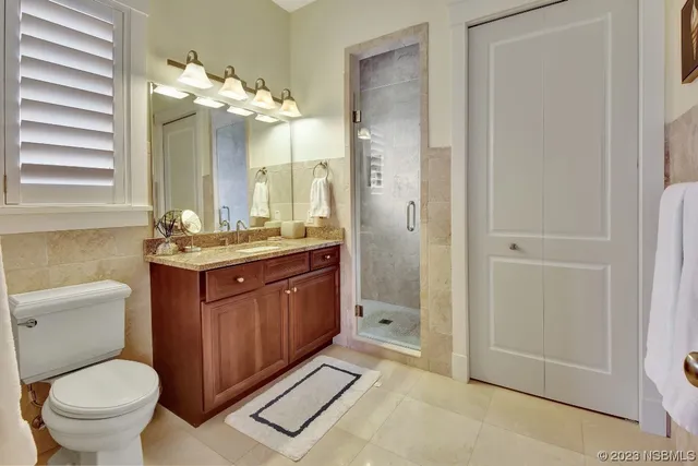 a bathroom with a granite countertop sink a toilet and shower