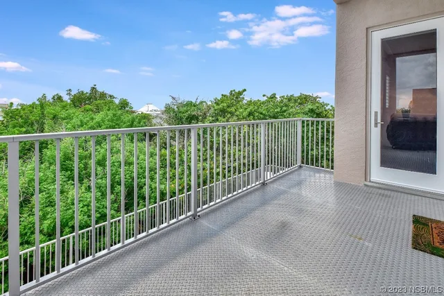 a bedroom with a bed a mirror and a large window