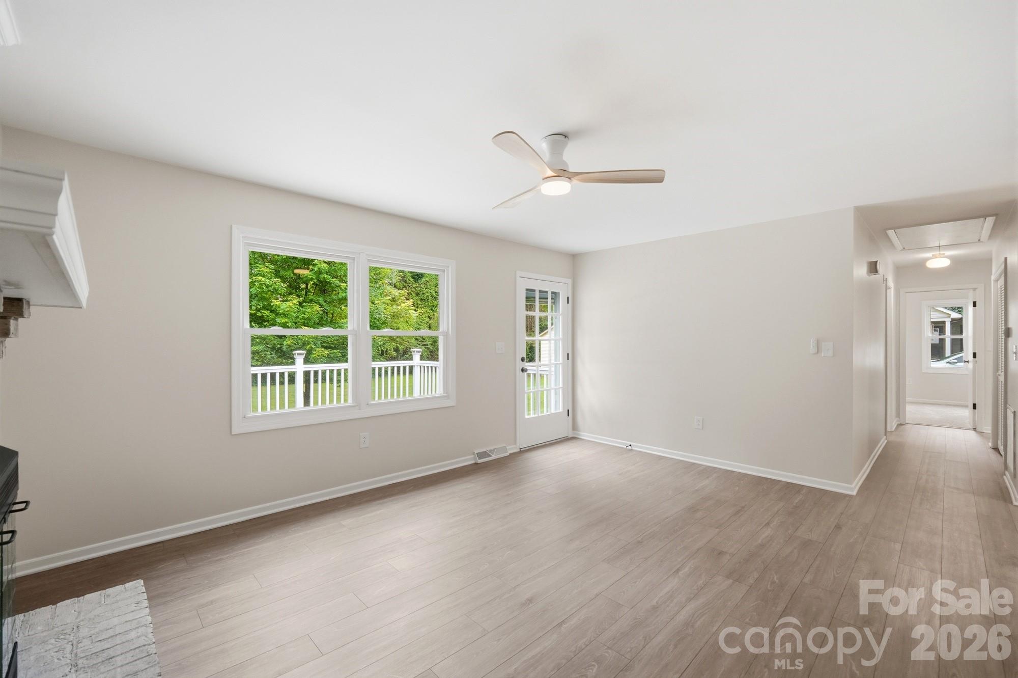 1235 Winecoff School Road Concord, NC 28027 - Photo 4 of 27 a view of empty room with wooden floor and fan