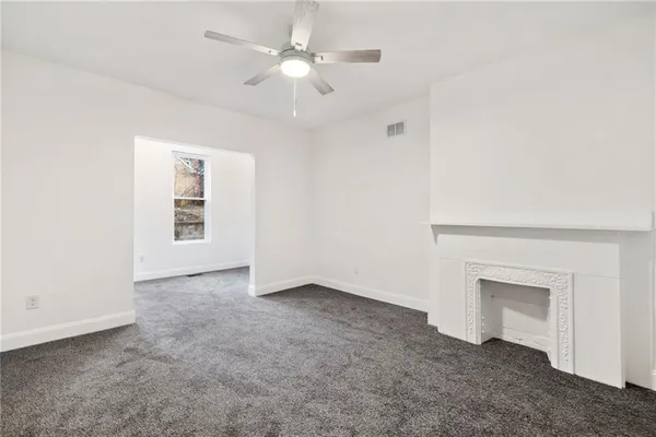 an empty room with a ceiling fan and a window