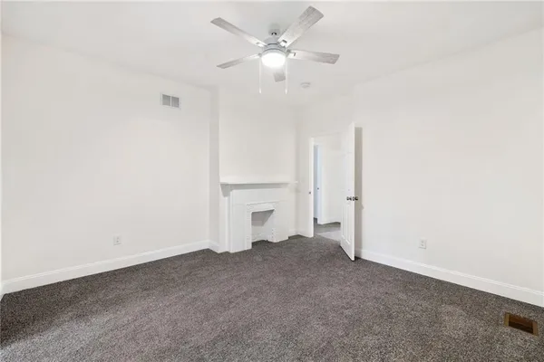 an empty room with a ceiling fan and a window