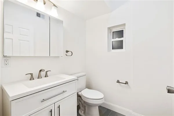 a bathroom with a sink mirror and toilet