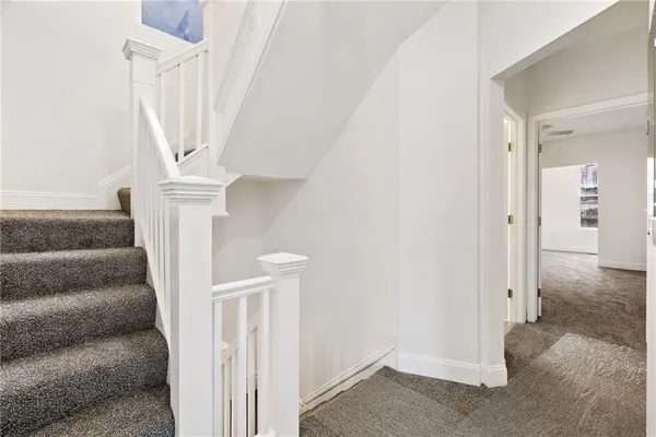 a view of staircase with white walls and railing