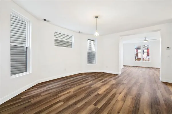 a view of an empty room window and wooden floor