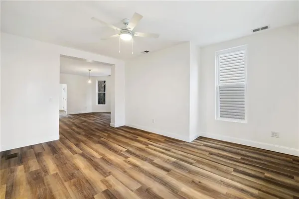 a view of a room with wooden floor and white walls