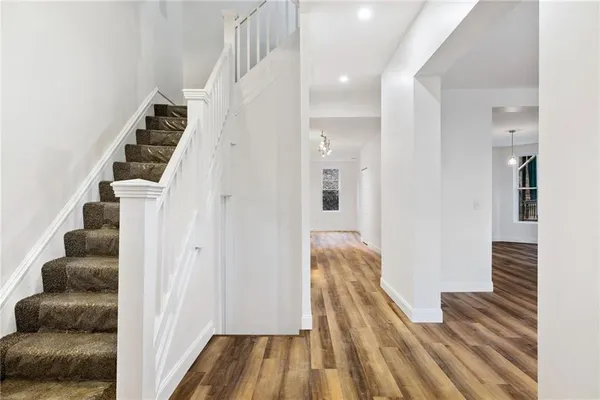 a view of a hallway with wooden floor and entryway