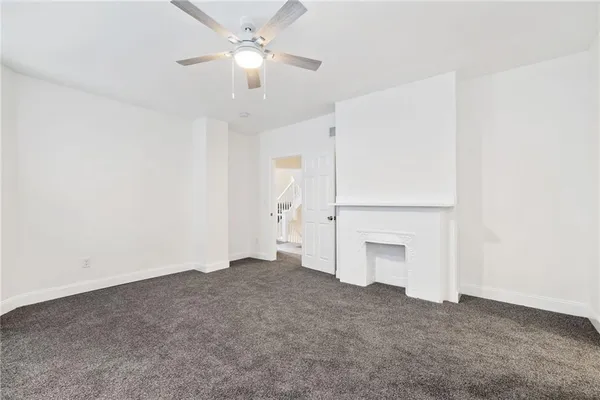 an empty room with a ceiling fan and a window