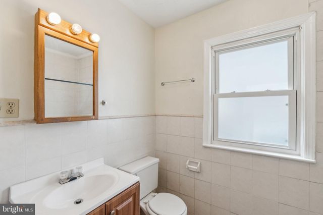 a bathroom with a sink mirror and toilet