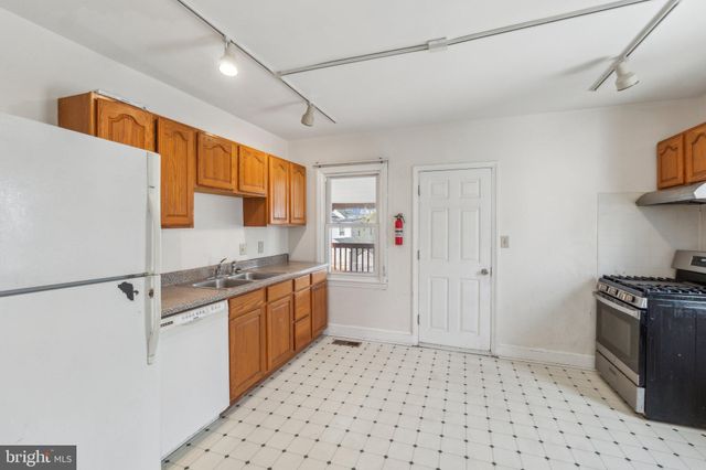 a kitchen with granite countertop a refrigerator and a stove