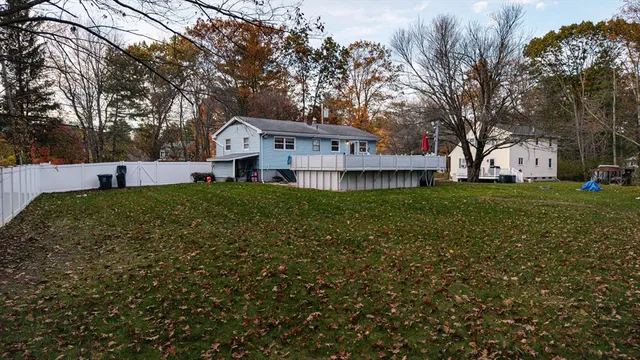 a house that is sitting in the grass with large trees