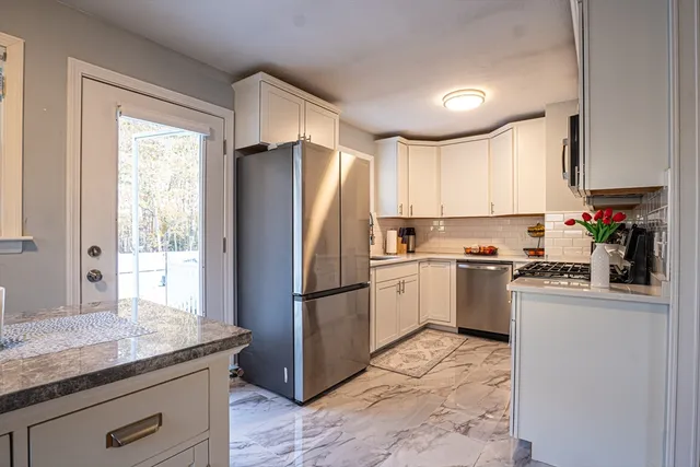 a kitchen with a refrigerator sink and cabinets