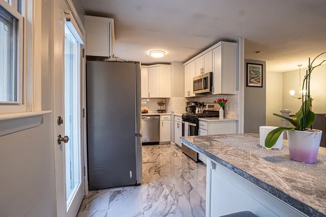a kitchen with granite countertop a refrigerator and a sink