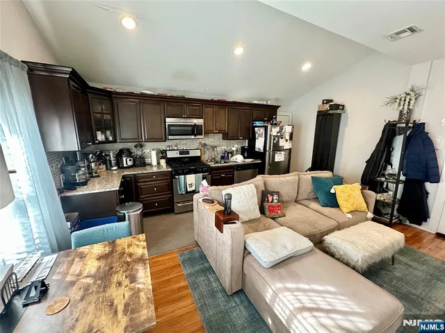 a living room with furniture a flat screen tv and a rug