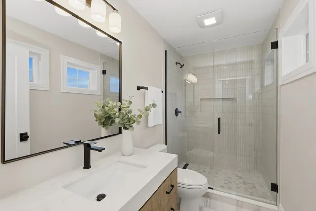 a bathroom with a sink a toilet and shower