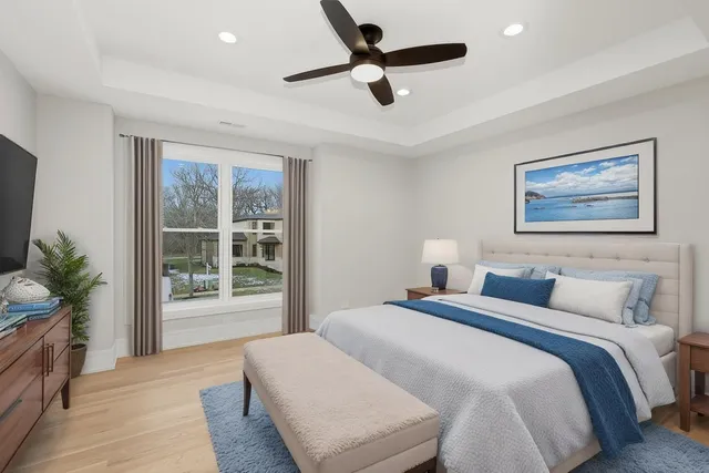a bedroom with a large bed and a chandelier