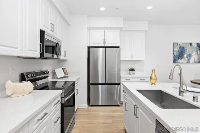 a kitchen that has a sink a table and chairs in it