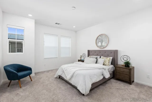 a bedroom with a bed a chair and potted plant