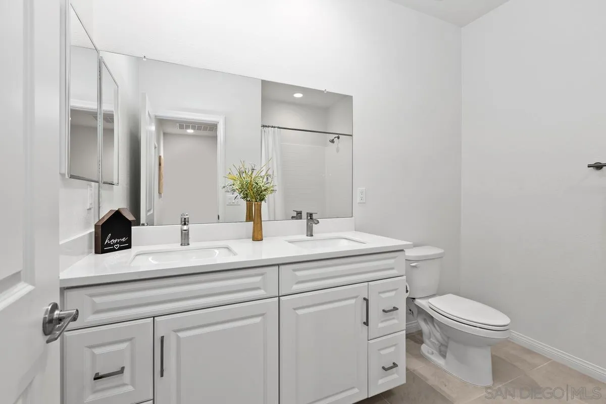 10149 Graphite Street Spring Valley, CA 91977 - Photo 22 of 35 a bathroom with a toilet sink and mirror