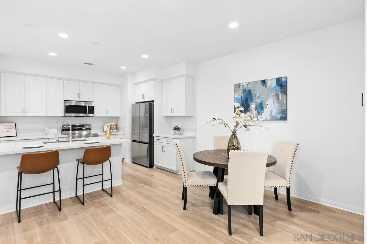 10149 Graphite Street Spring Valley, CA 91977 - Photo 8 of 35 a kitchen with stainless steel appliances a dining table chairs and wooden floor