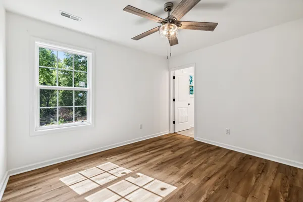 a view of a big room with wooden floor and windows in a room