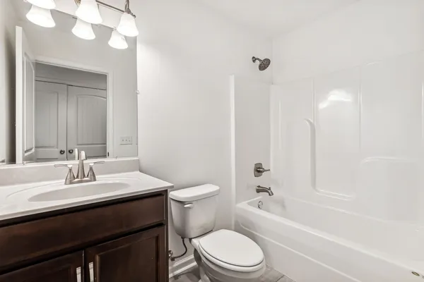 a bathroom with a sink a toilet a mirror and shower