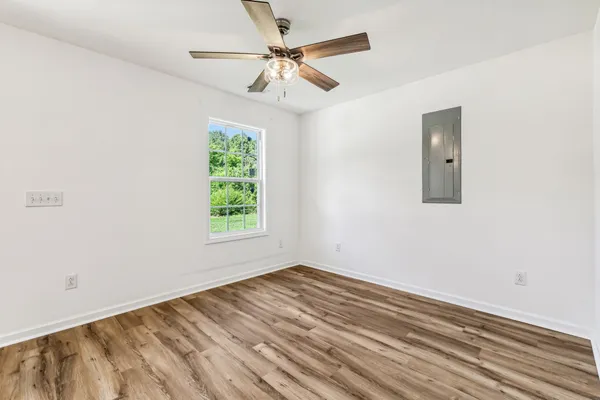 an empty room with a window and a ceiling fan
