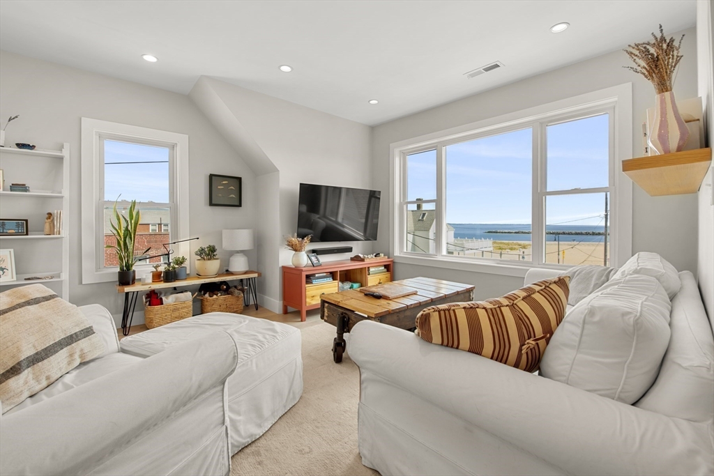 a living room with furniture flat screen tv and a large window
