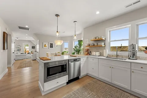 a kitchen with stainless steel appliances granite countertop a sink a stove and a wooden floors