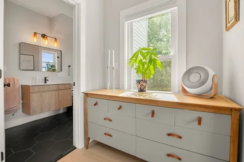 a bathroom with a granite countertop sink a potted plant and a window