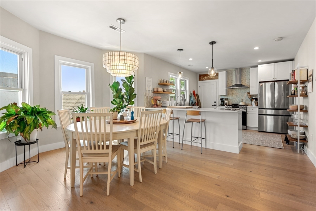 51 Cutler Street, Unit 3 Winthrop, MA 02152 - Photo 6 of 28 a dining room kitchen with granite countertop stainless steel appliances a dining table chairs stove and refrigerator
