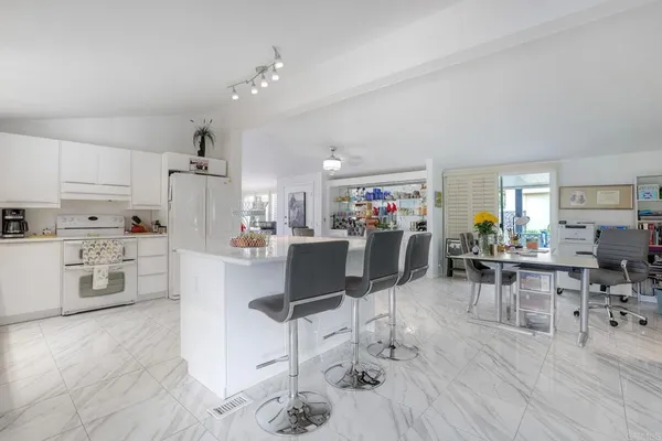a living room with furniture a dining table and kitchen view