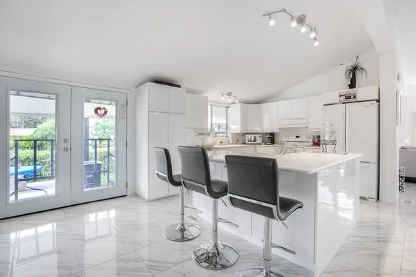 a kitchen with a dining table chairs and refrigerator