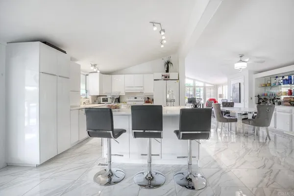 a living room with lots of furniture and kitchen view