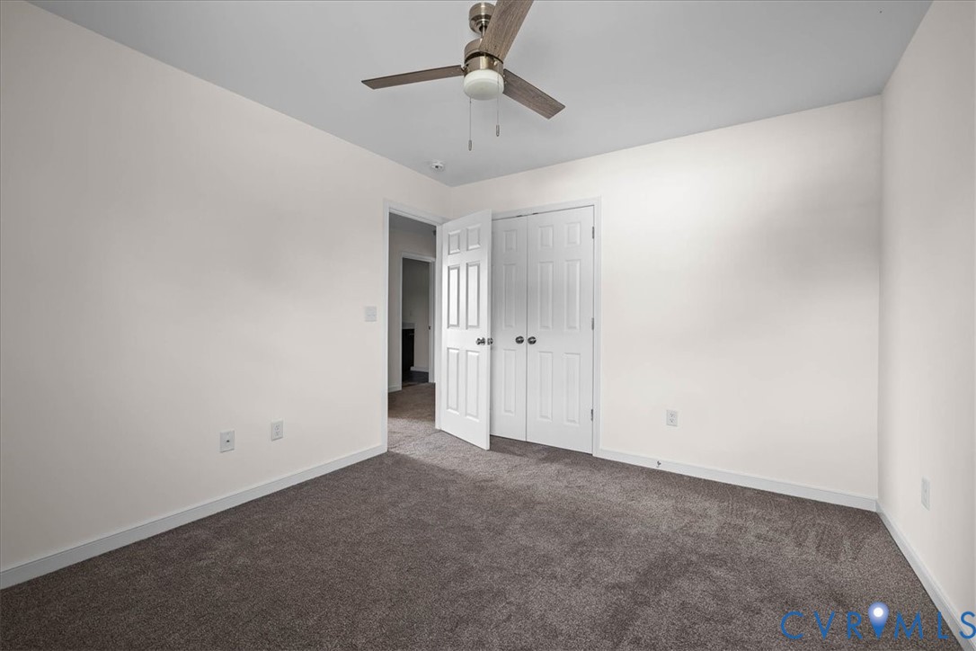 11325 Webb Road Disputanta, VA 23842 - Photo 23 of 32 an empty room with a ceiling fan and carpet