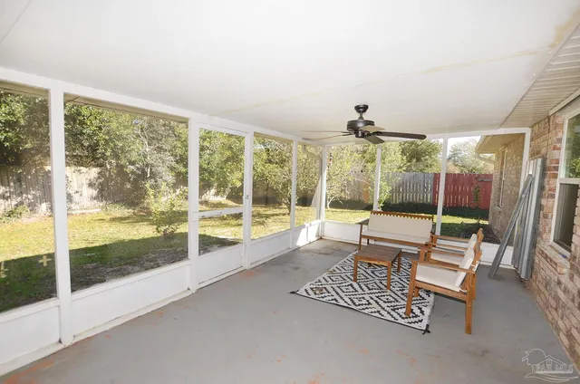 a living room with furniture and a floor to ceiling window