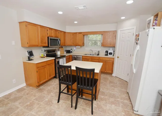 a kitchen with a sink a stove a refrigerator a dining table and chairs