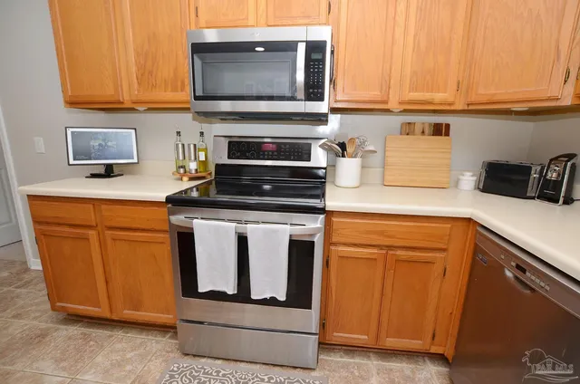 a kitchen with stainless steel appliances granite countertop a stove a sink and a microwave