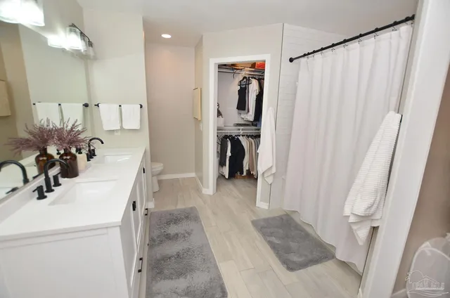 a bathroom with a sink a toilet and a mirror