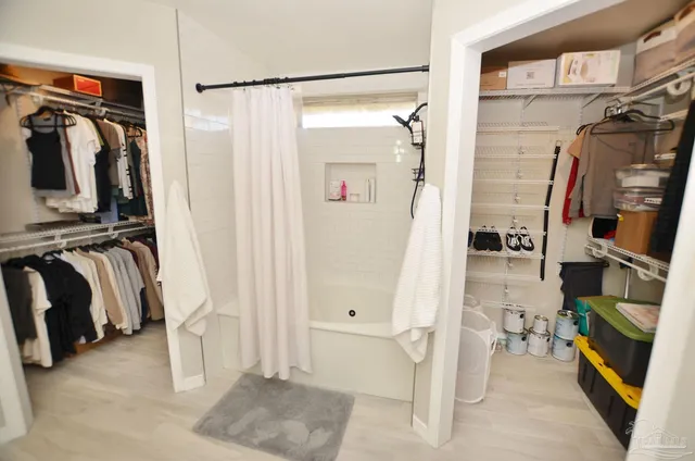 a view of walk in closet with clothes and shoes