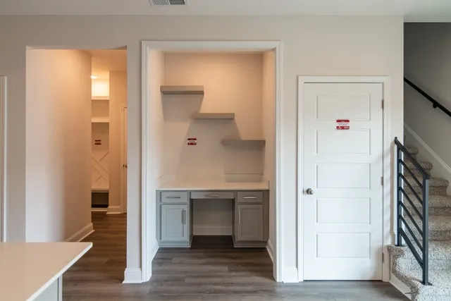 a view of a hallway with wooden floor and staircase