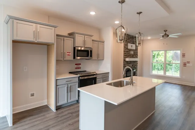 a kitchen with kitchen island a counter top space appliances and a wooden floor