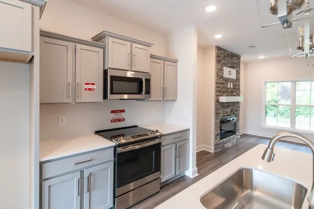 a kitchen with stainless steel appliances a stove microwave and sink