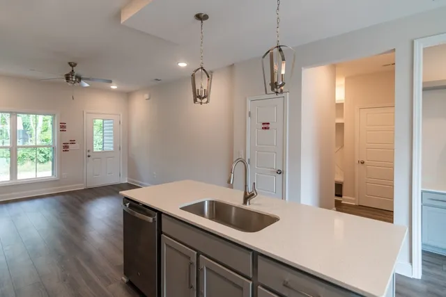 a kitchen with a sink a counter space and wooden floor