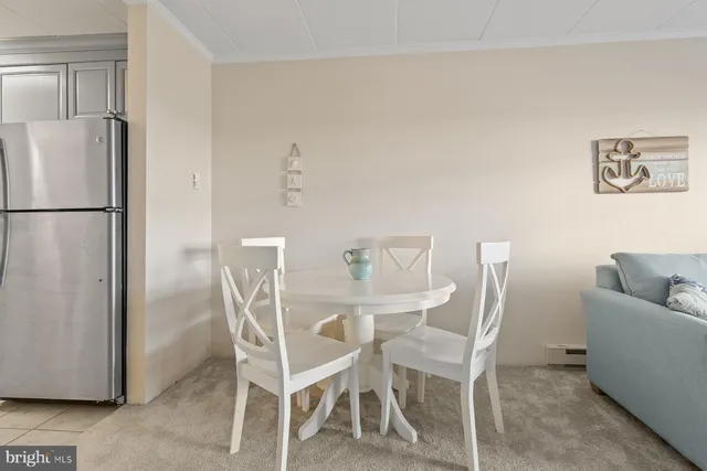 a dining room with furniture and a refrigerator