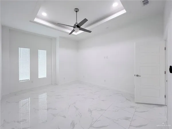 an empty room with fan and windows