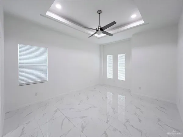 en empty room with windows and ceiling fan